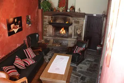 a living room with a fireplace and a table and chairs at Casa Vixide in Lalín