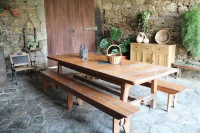 a wooden table and benches on a patio at Casa Vixide in Lalín