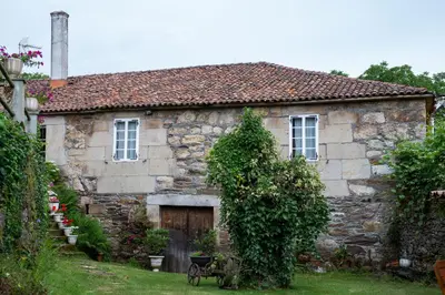 an old stone house with a wooden door at Casa Vixide in Lalín