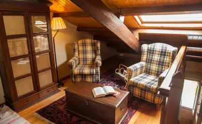 a living room with two chairs and a table with a book at Casa do Mudo in Cervo