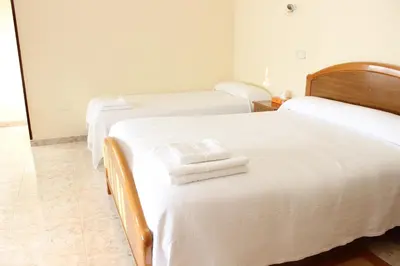 two beds in a room with white sheets and towels at O Cruceiro in Puentedeume