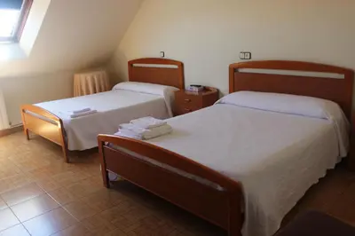 a bedroom with two beds and a window at O Cruceiro in Puentedeume