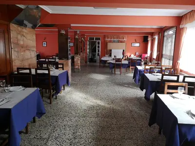 a dining room with blue tables and chairs at O Cruceiro in Puentedeume