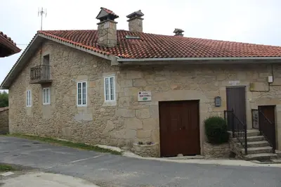 a stone house with a door and a balcony at Casa Solveira in Piñeiro