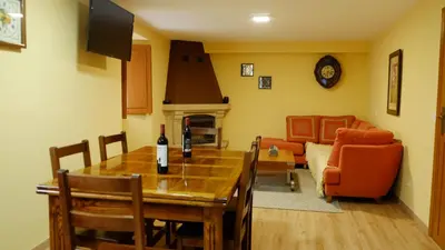 a dining room and living room with a table and a couch at Casa Solveira in Piñeiro