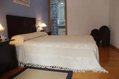 a bedroom with a bed with a white blanket on it at Casa Solveira in Piñeiro
