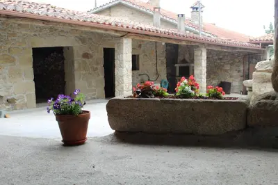 a stone house with two flower pots in front of it at Casa Solveira in Piñeiro