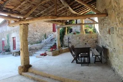 a patio with a table and chairs under a wooden roof at Casa Solveira in Piñeiro