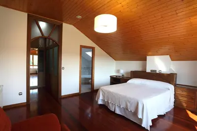 a bedroom with a bed and a wooden ceiling at A Quinta de Lapido in Ortoño