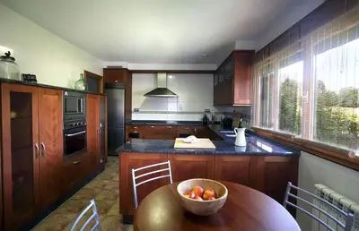 a kitchen with a bowl of fruit on a wooden table at A Quinta de Lapido in Ortoño