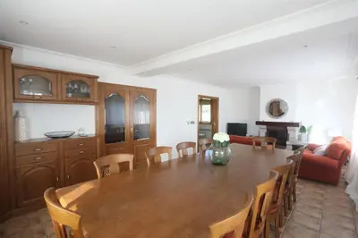 a kitchen and dining room with a wooden table and chairs at A Quinta de Lapido in Ortoño