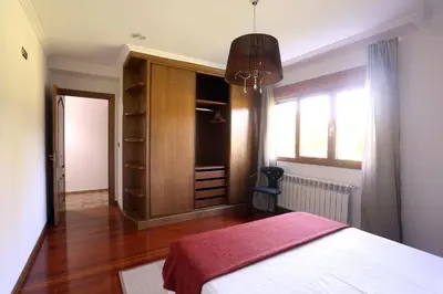 a bedroom with a white bed and a closet at A Quinta de Lapido in Ortoño