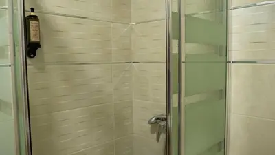 a shower with a glass door in a bathroom at Pensión Casa Douro in Santiago de Compostela