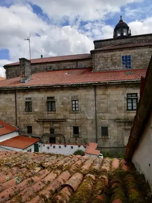 an old stone building with a red roof at Pensión Casa Douro in Santiago de Compostela