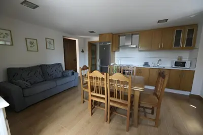 a kitchen and living room with a table and chairs at Vivienda Uso Turístico Prado novo in Suarbol