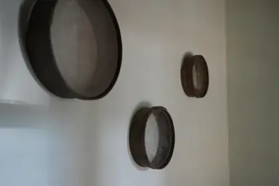 a white wall with a mirror and three wooden plates at Vivienda Uso Turístico Prado novo in Suarbol