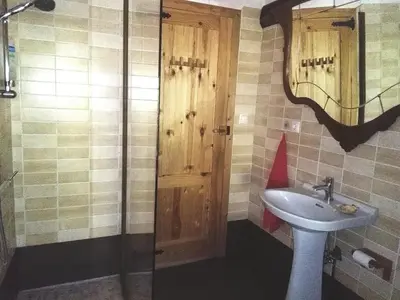a bathroom with a sink and a shower with a mirror at Casa do Solpor in La Teijeira