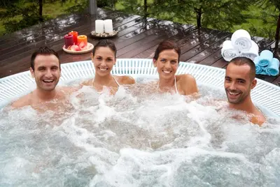 a group of four people in a hot tub at Balneario Acuña in Caldas de Reis