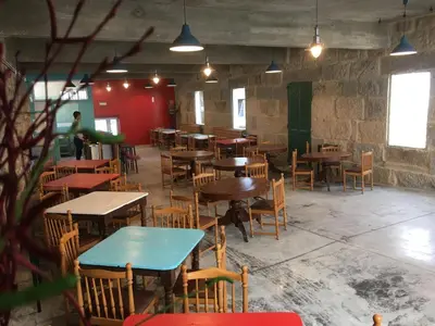 an empty restaurant with tables and chairs in a room at Balneario Acuña in Caldas de Reis