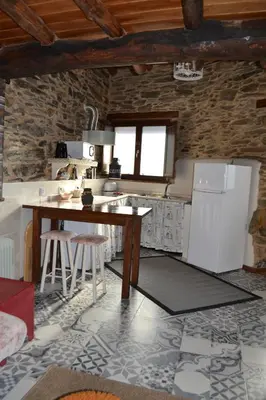 a kitchen with a table and a refrigerator at Casa do Conto in Doade