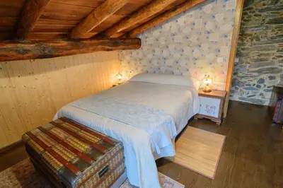 a bedroom with a bed in a room with wooden ceilings at Casa do Conto in Doade