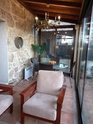 a patio with a couch and a table and chairs at Casa Rural Cabo de Aráns in Oroso