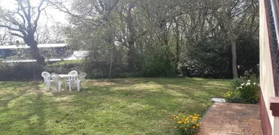 two white chairs and a table in a yard at Casa de Corbelle in Muimenta