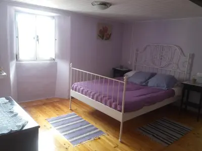 a bedroom with a bed with purple sheets and a window at Casa de Corbelle in Muimenta