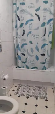 a bathroom with a blue shower curtain with a toilet at Casa de Corbelle in Muimenta