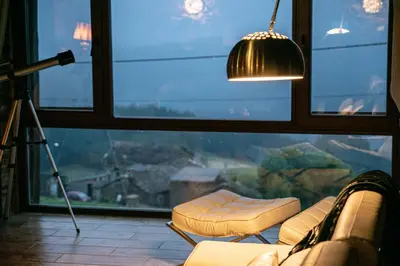a living room with a couch and a large window at Complejo Rural Lar de Vies in A Pontenova