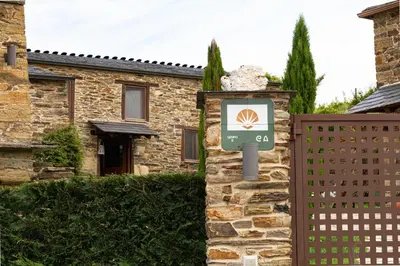a sign in front of a house with a fence at Complejo Rural Lar de Vies in A Pontenova