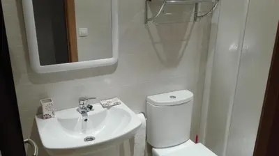 a bathroom with a white toilet and a sink at Apartment Javier in Foz