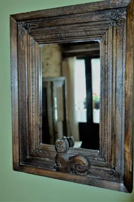 a mirror with a wooden frame hanging on a wall at Casa Apilladeira in Puentedeume