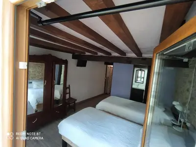 a bedroom with two beds and a mirror at Casa Apilladeira in Puentedeume