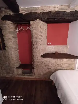 a bedroom with a bed and a red wall at Casa Apilladeira in Puentedeume