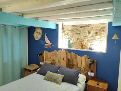 a bedroom with a bed with a wooden head board at Casa Apilladeira in Puentedeume