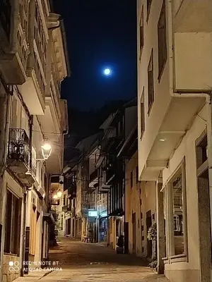 an empty street at night with a moon in the sky at Casa Apilladeira in Puentedeume