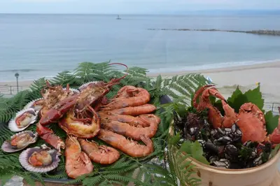 a plate of lobsters and other seafood on the beach at Hotel Nordés in Burela de Cabo