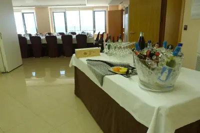 a table with a bucket of wine bottles and glasses at Hotel Nordés in Burela de Cabo