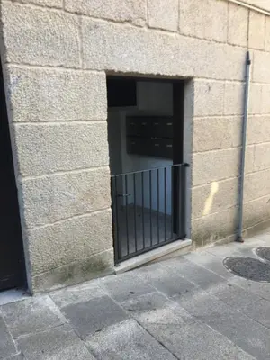 a window in a brick building with a gate at Ático Lobariñas in Allariz