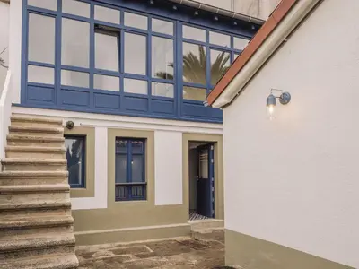 a house with blue windows and a staircase at Santiago KM-0 in Santiago de Compostela