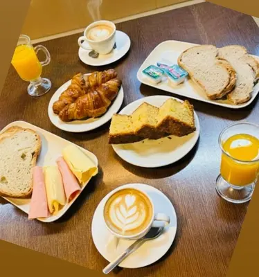 a table topped with plates of breakfast foods and coffee at Hotel Spa Galatea in Burela de Cabo