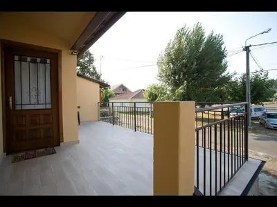a porch with a wooden door and a fence at Casa das Pozas in Distriz