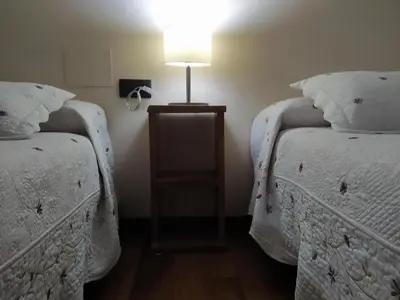 a bedroom with two beds and a lamp on a night stand at Casa das Pozas in Distriz