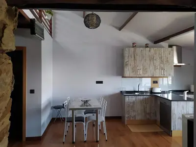 a kitchen with a table and chairs in a room at Casa das Pozas in Distriz