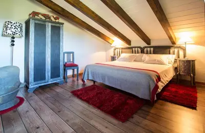 a bedroom with a bed and a wooden floor at A Aira da Petada Hotel Boutique in Corzos