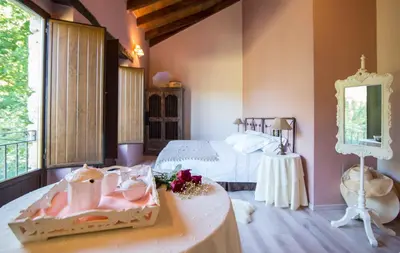 a bedroom with two beds and a table with a cake on it at A Aira da Petada Hotel Boutique in Corzos