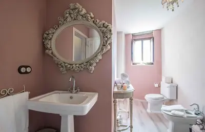 a bathroom with a sink and a toilet and a mirror at A Aira da Petada Hotel Boutique in Corzos