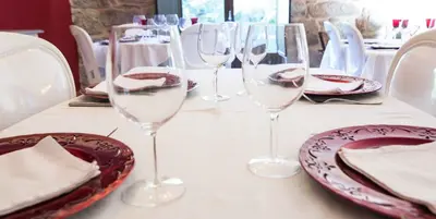 a table with wine glasses and plates on it at A Aira da Petada Hotel Boutique in Corzos