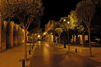 an empty street at night with trees and lights at Hotel Restaurante San Anton in Tapia de Casariego